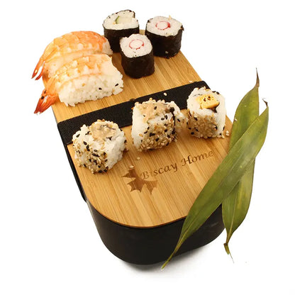 Boite bento noire avec des sushis et des décorations sur le couvercle