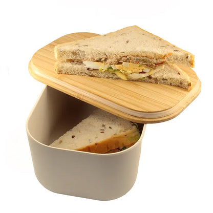 Boite bento blanche avec un sandwich à l'intérieur et sur le couvercle