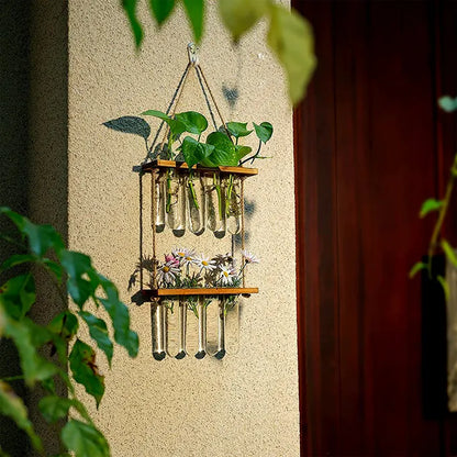 Vase tubes suspendu à un mur la nuit avec des plantes vertes