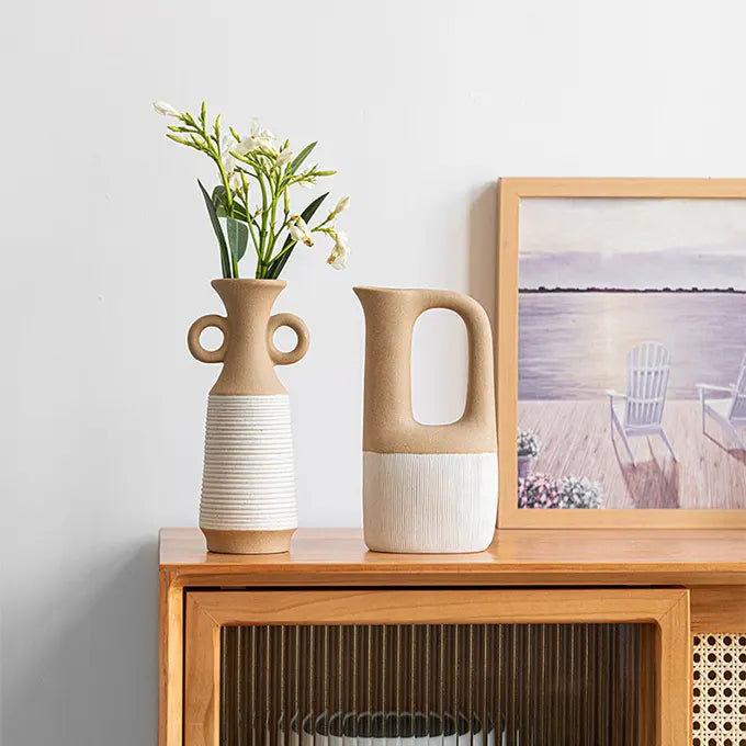 2 vases en céramiques sur une table avec un cadre